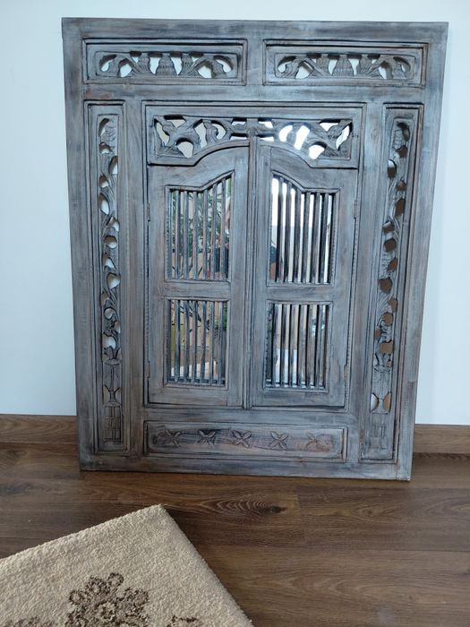 Lustro z drewnianą ramą.