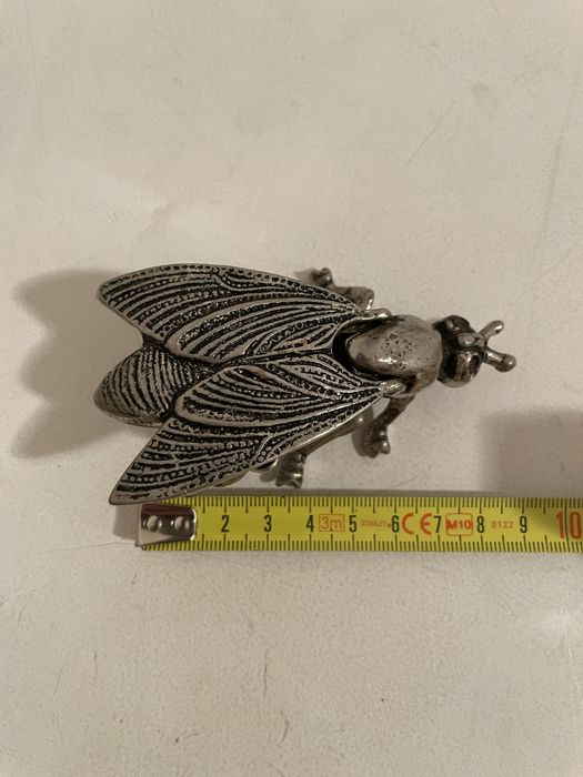 Mosca em metal prateado