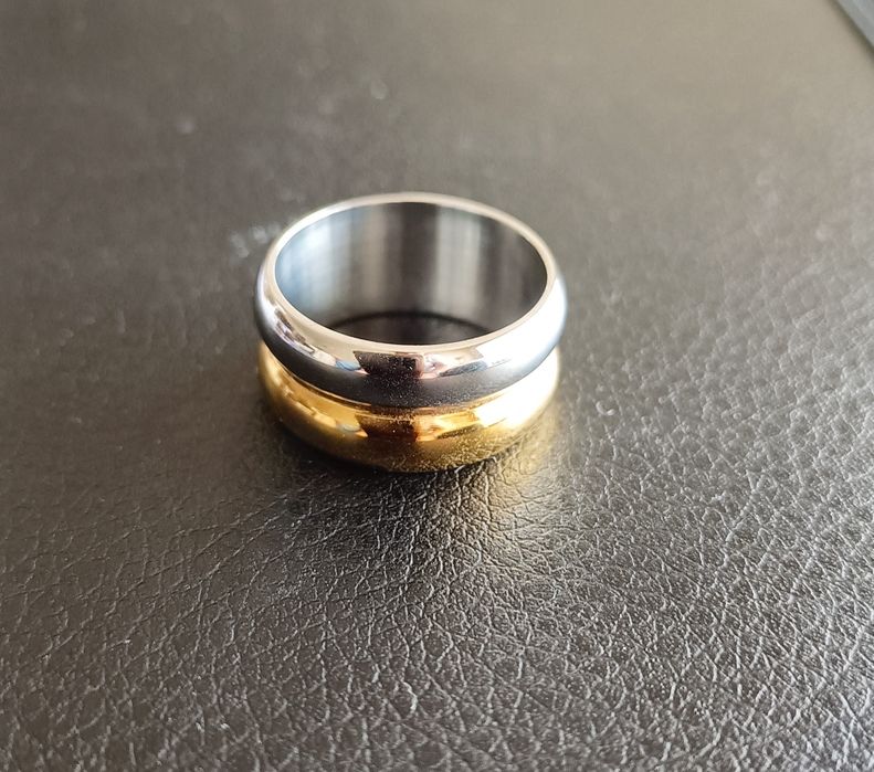 Aliança em aço dourado e prateado.