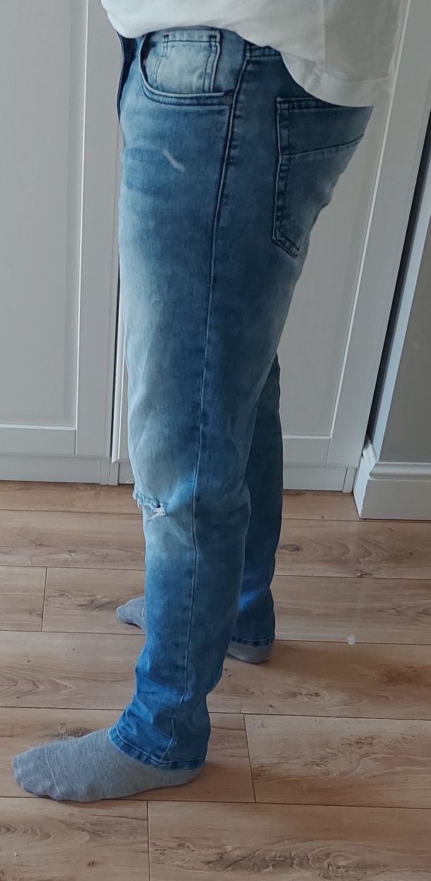 Jeansy Reserved 
Rozmiar 32/32 Niebieski jeans
z dziurami