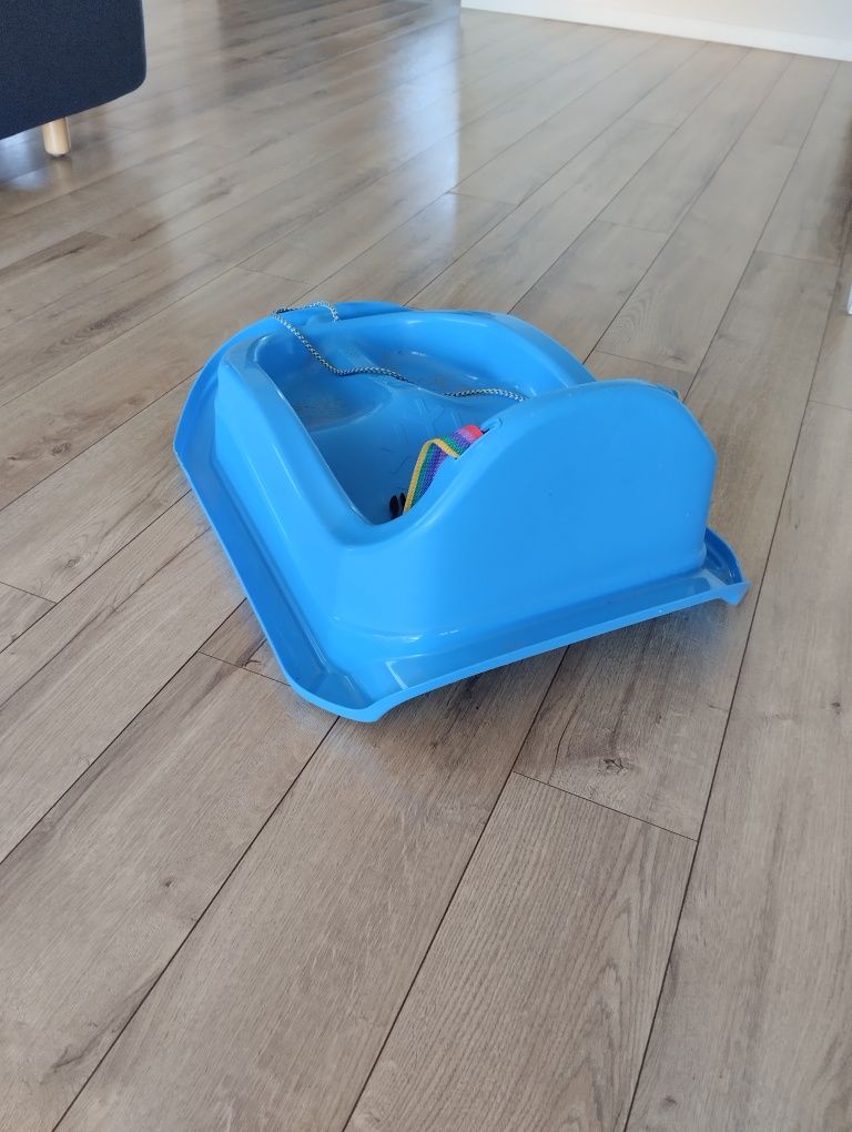 Niebieskie plastikowe sanki z szelkami