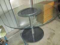 Mesa redonda com centro em granito e tampo de vidro.