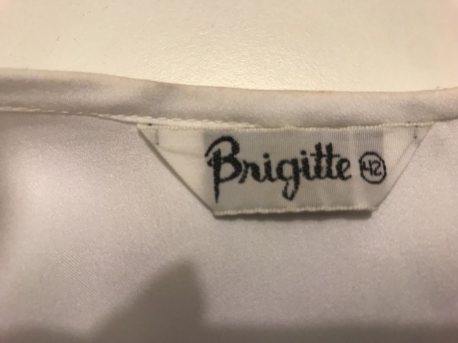 Blusa branca tipo seda com manga comprida.