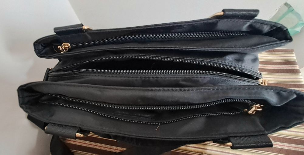 Carteira preta em tecido impermeável com várias divisórias, pratica e