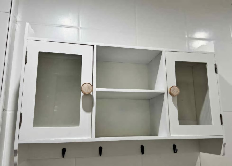 Biała szafka wisząca z półkami i szklanymi drzwiczkami