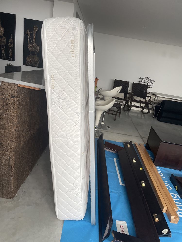 Cama de casal de madeira escura com mesas de cabeceira