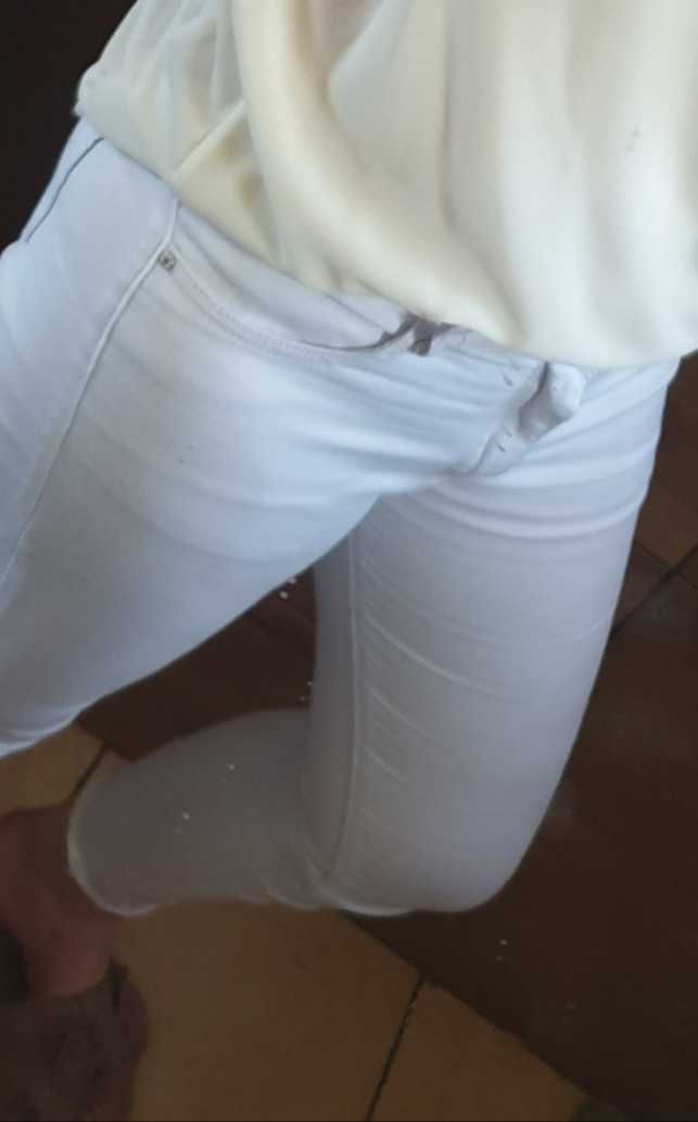 Białe spodnie z poszarpaną nogawką