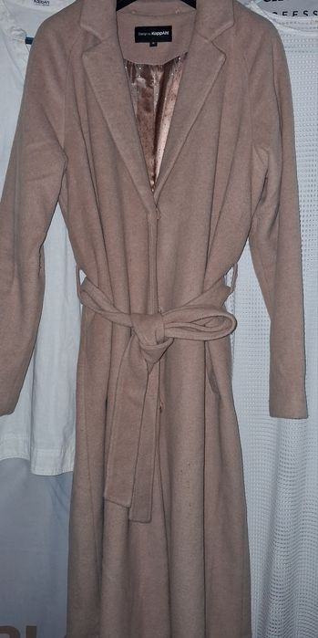 beżowy płaszcz z paskiem marki KappAhl.
