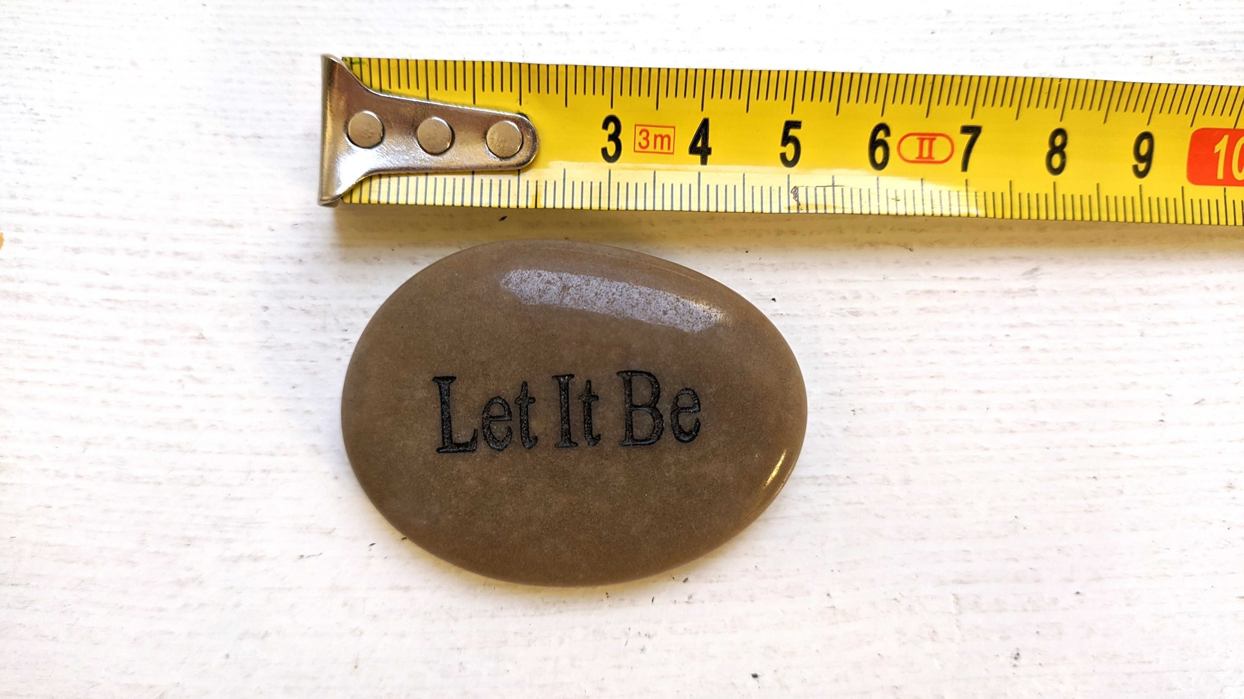 Płaski owalny kamień z wyrzeźbionym napisem "Let it be". 5 cm