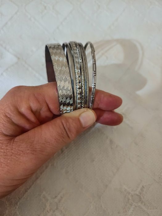 Pulseira com várias pulseiras , todas diferentes, em aço