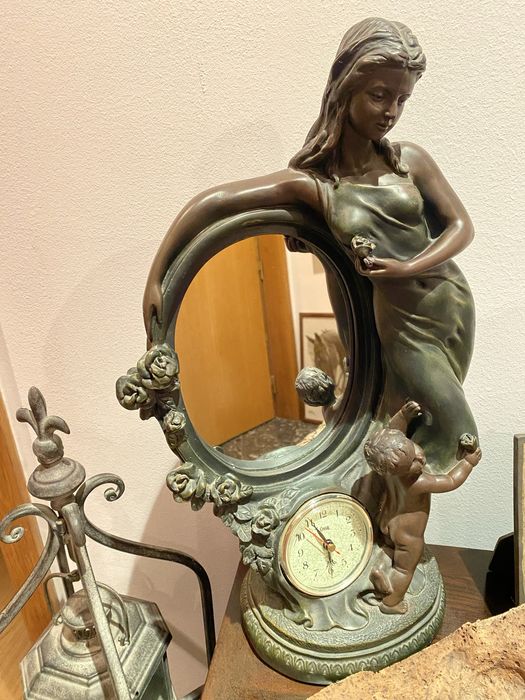 Estatueta de mulher, relógio e espelho