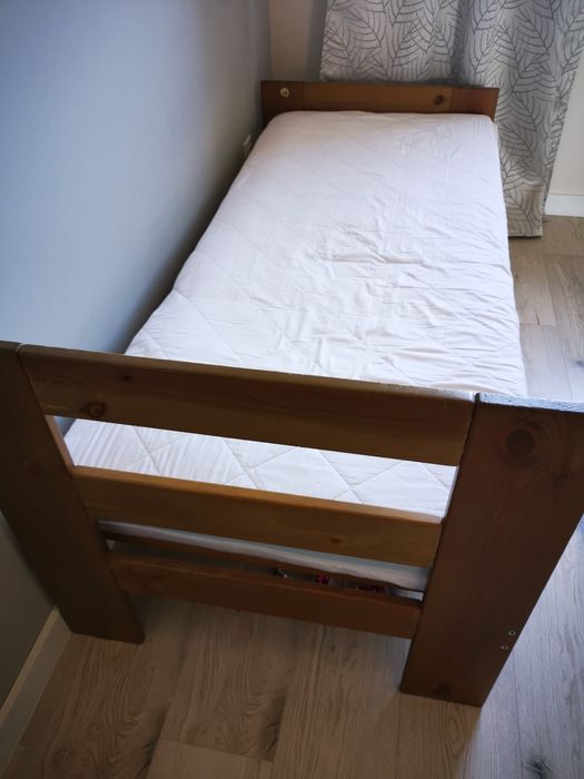 Łóżko dziecięce z drewna z materacem.