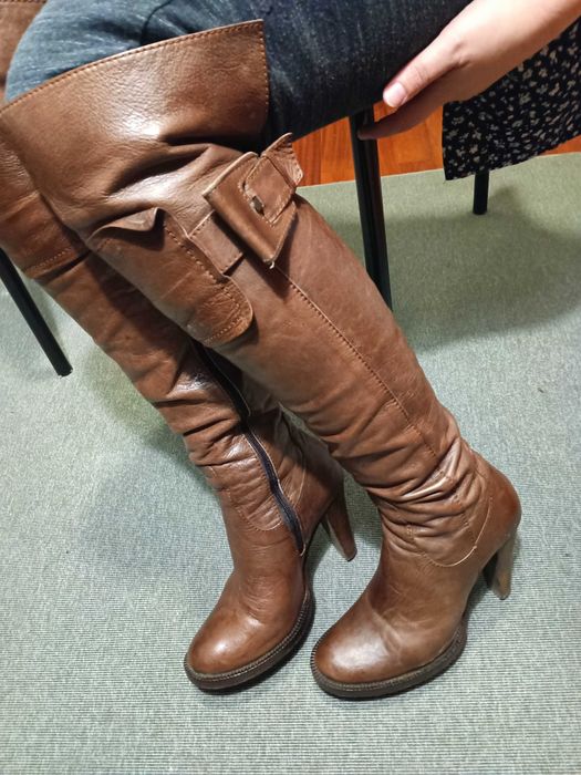 Botas castanhas em pele de cano alto ligeiramente acima do joelho