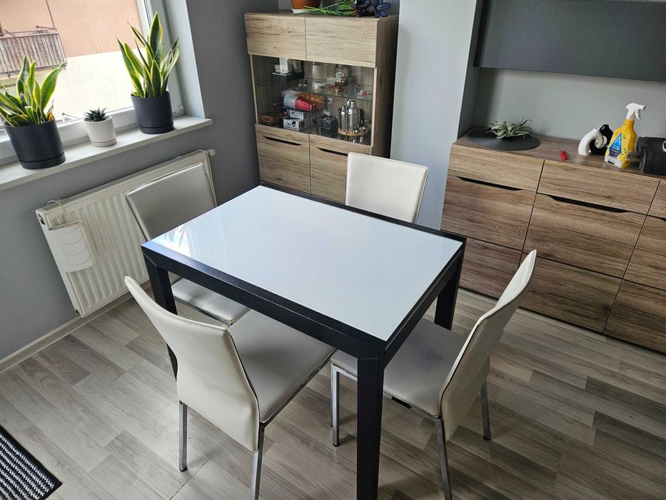 Stół rozkładany ze szklanym blatem + 4 białe krzesła.