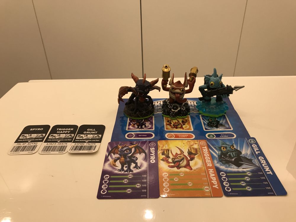 Varios Skylanders ainda com suas cartas e autocolantes