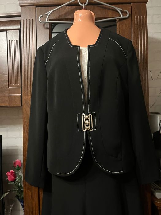 Żakiet czarny z ozdobnym zapięciem.