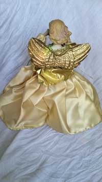 Aniołek stojący w złotej sukni.