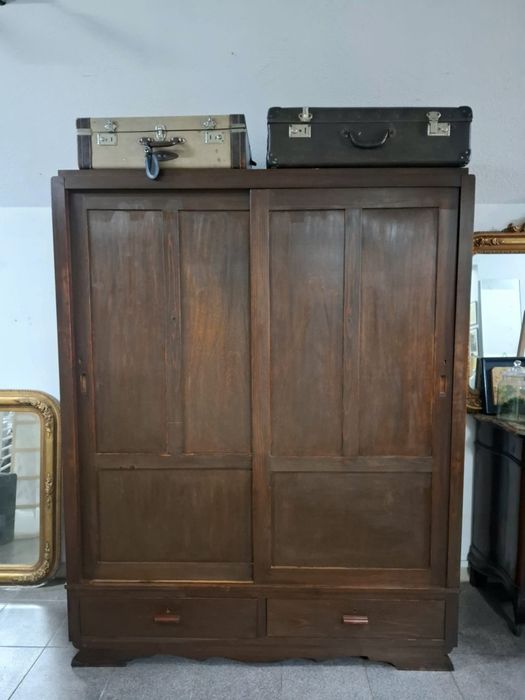 Roupeiro em madeira maciça com portas de correr.