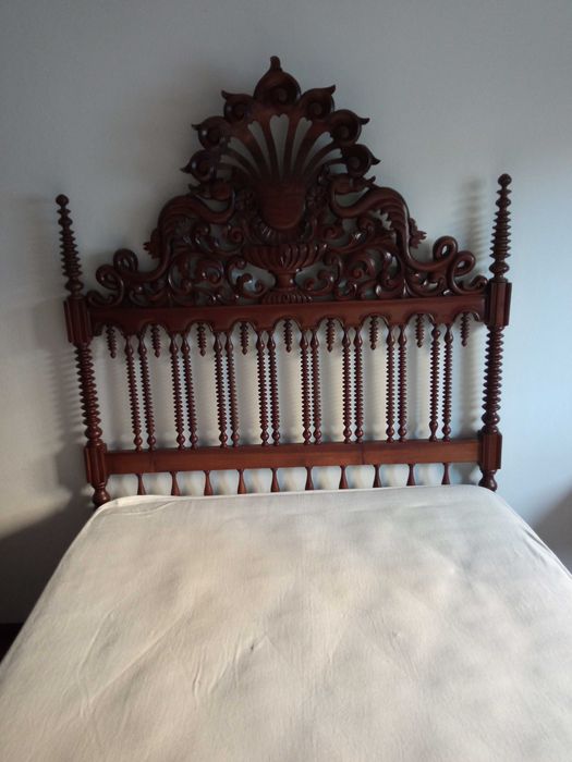 Cama em madeira maciça com cabeceira trabalhada com torneados