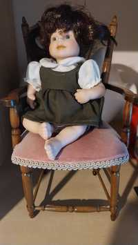 Stara lalka porcelanowa na krzesle