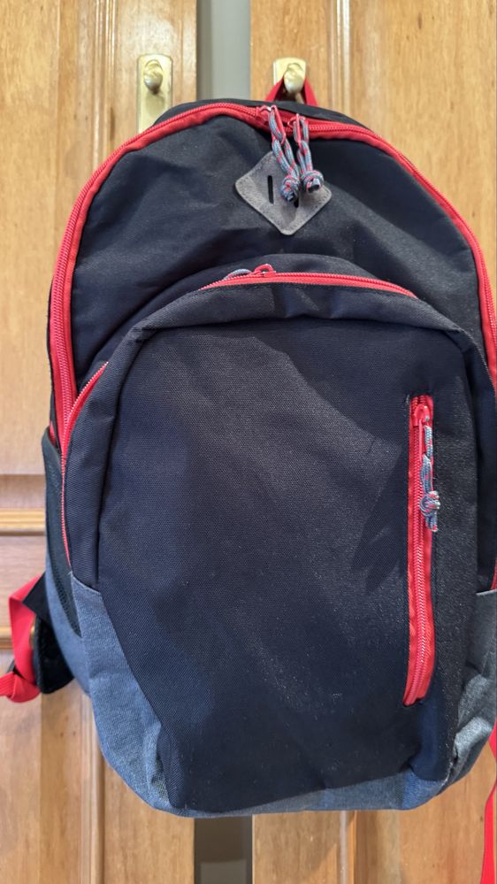Mochila preta com os fechos em vermelho