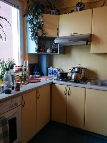 Meble kuchenne z żółtymi frontami i niebieskimi fragmentami mebli.
