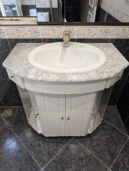 Lavatório de cerâmica embutido em móvel de mármore com gavetas
