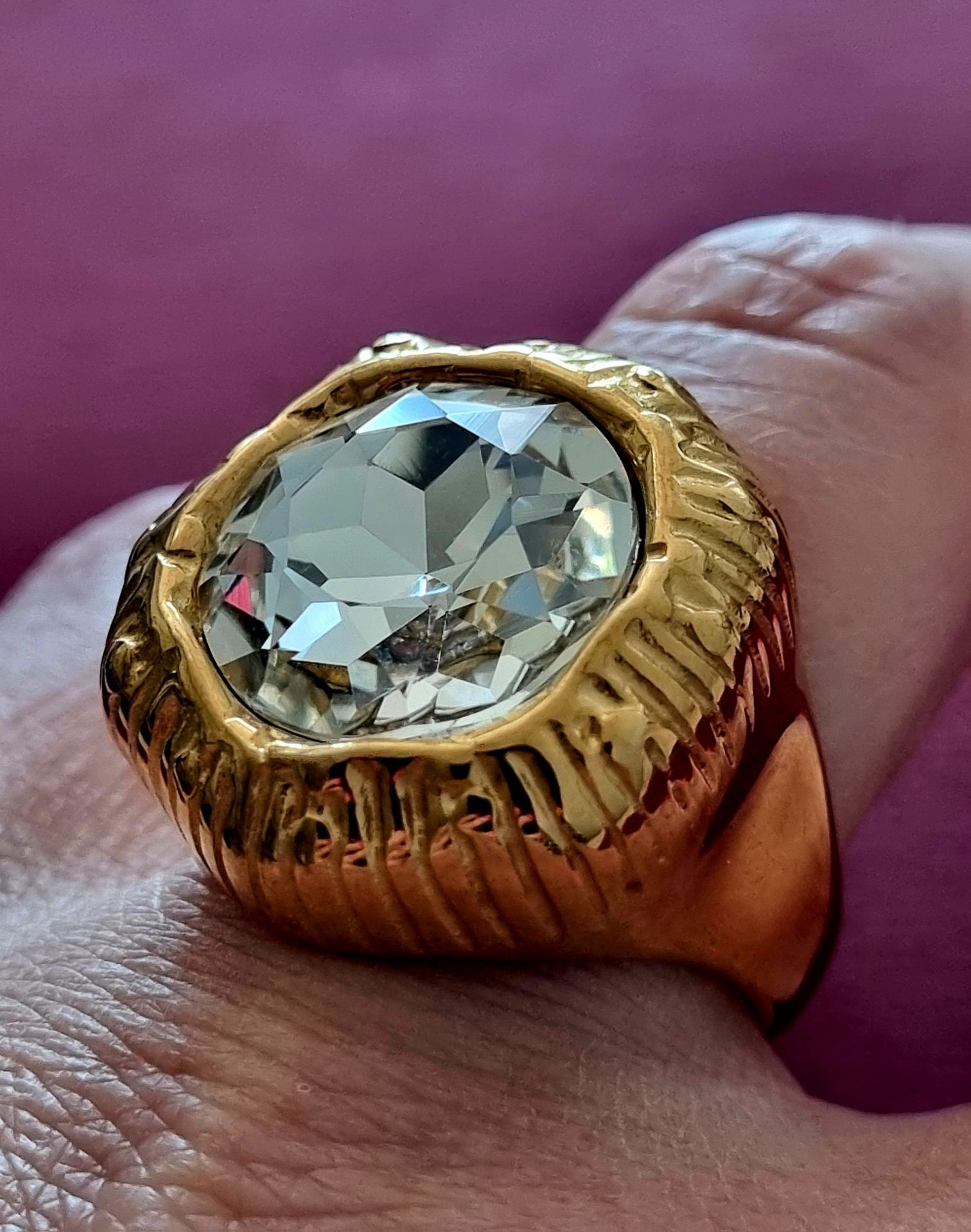 Anel dourado, em aço, com grande ponto de luz. T18