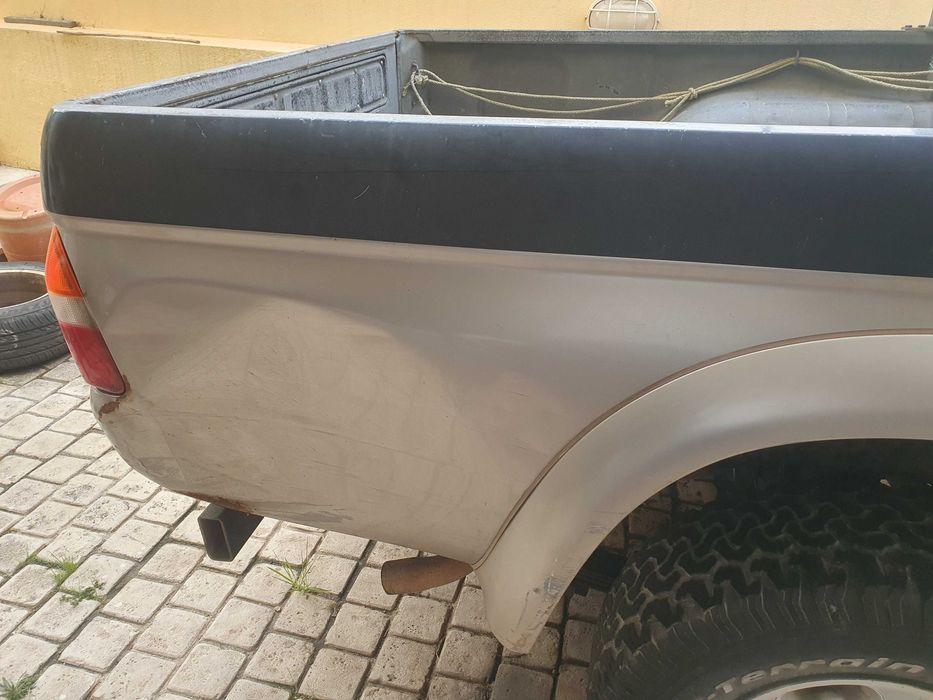Mitsubishi L200 preta e prateada com engate de reboque