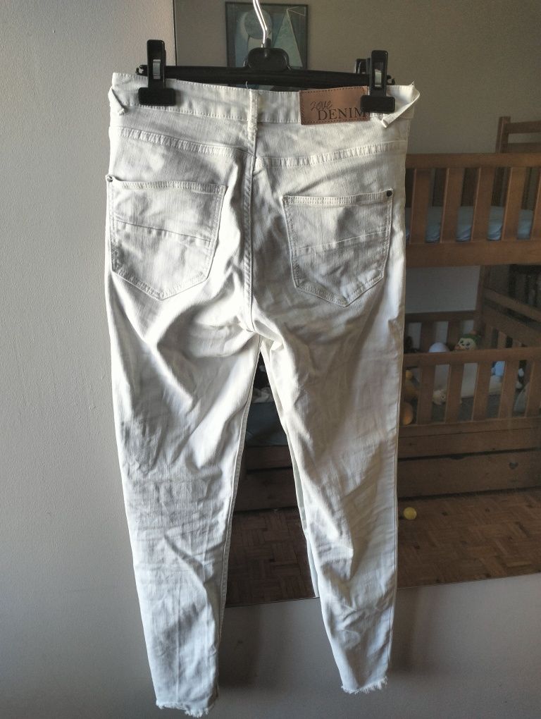 Białe jeansy z postrzępionymi nogawkami