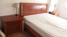 Quarto de casal completo. Cama, mesas de cabeceira e camiseiro