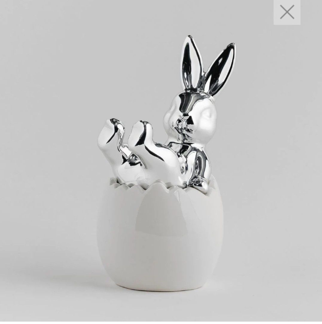 Zajaczek srebrny siedzący w białej ceramicznejskorupce