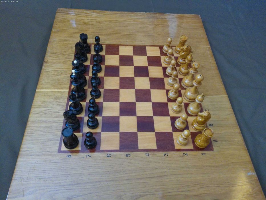 Шахматная доска с большими деревянными шахматными фигурами.