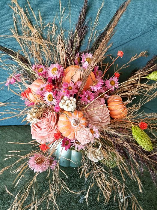 Jesienny stroik w szklanym wazonie dynia ze świecami sojowymi