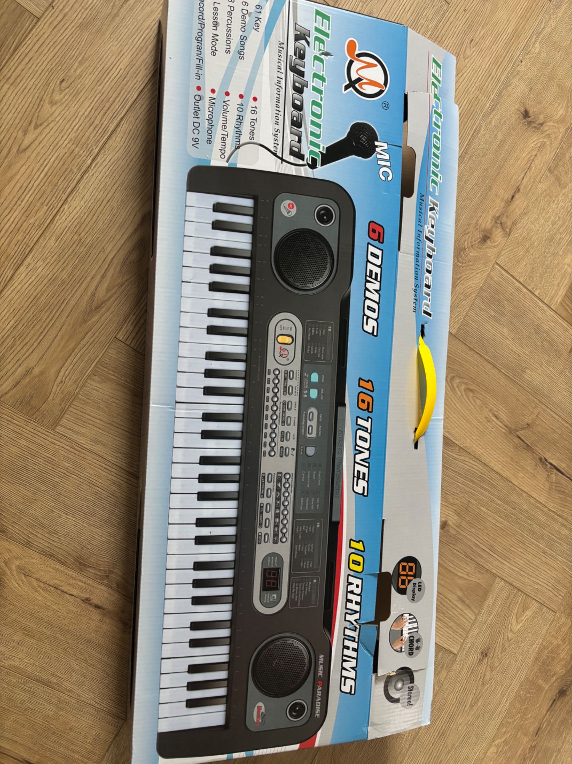 Keyboard z mikrofonem, ładowarką i instrukcją obsługi.