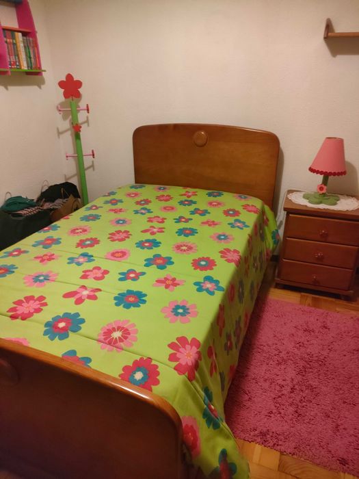 Quarto com cama, mesa de cabeceira e roupeiro