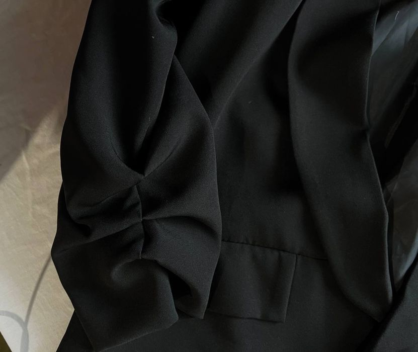 Елегантний подовжений чорний піджак.