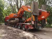 Transport maszyn rolniczych koparek na powrocie niskopodwozia z Europy