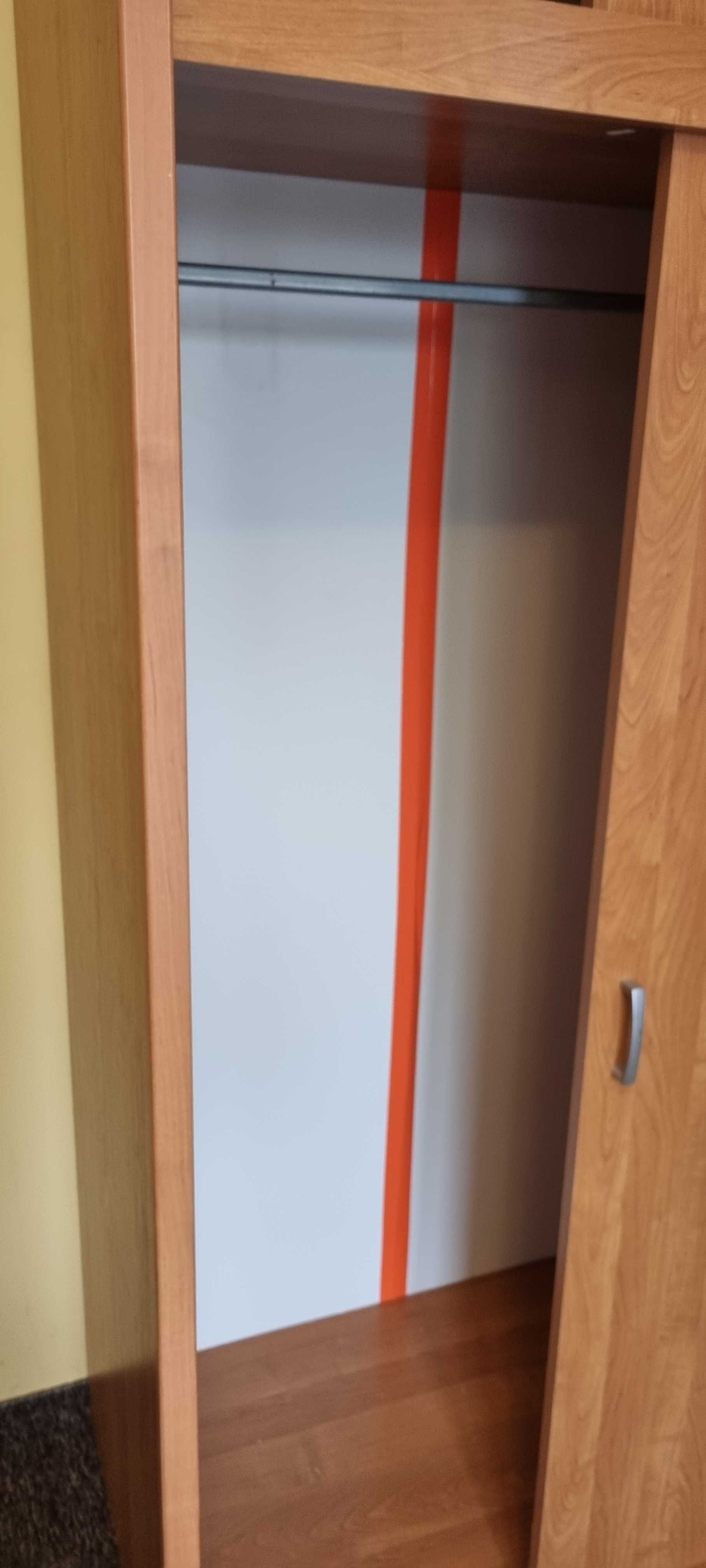 Szafa dwudrzwiowa z odsuwanymi drzwiami w kolorze drewna.