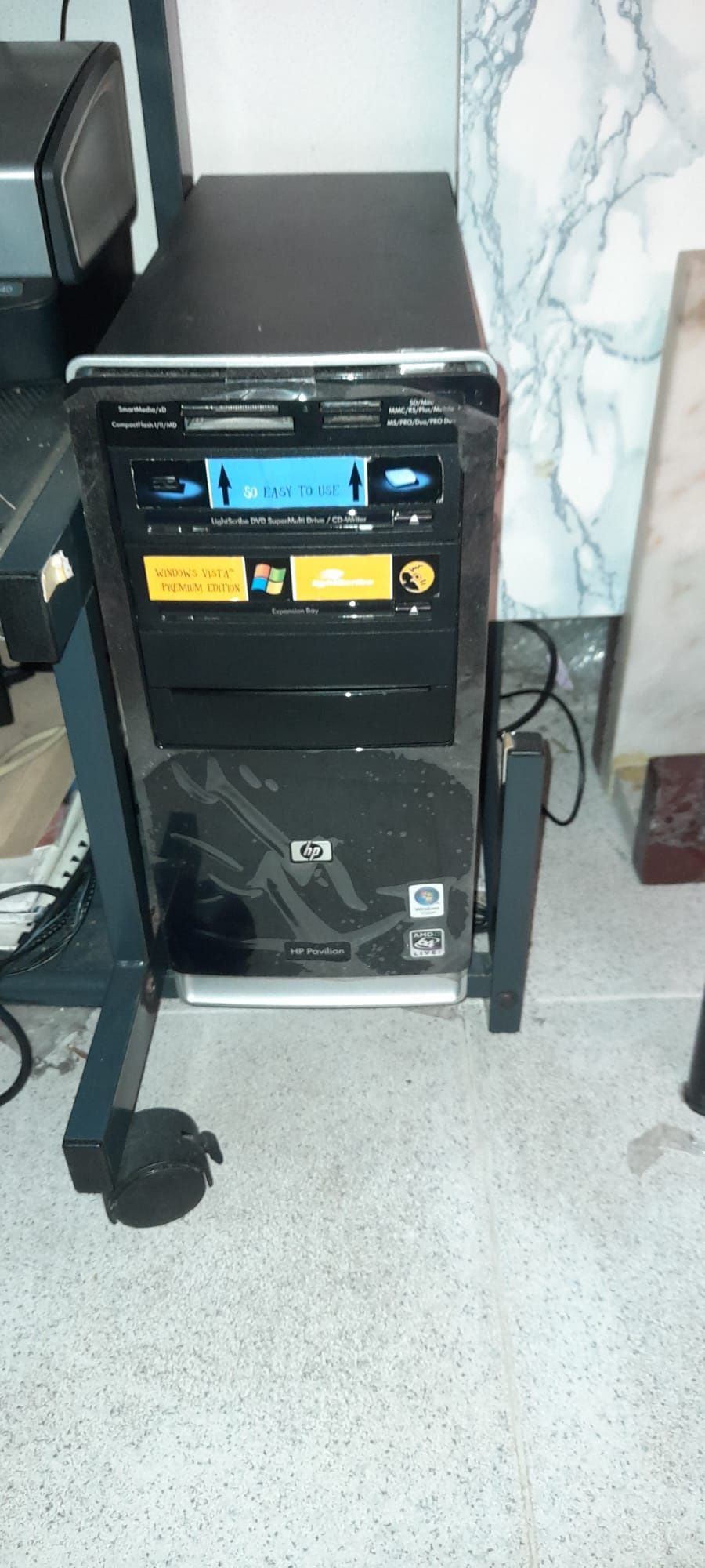 Computador HP, impressora, sistema de som e secretária.