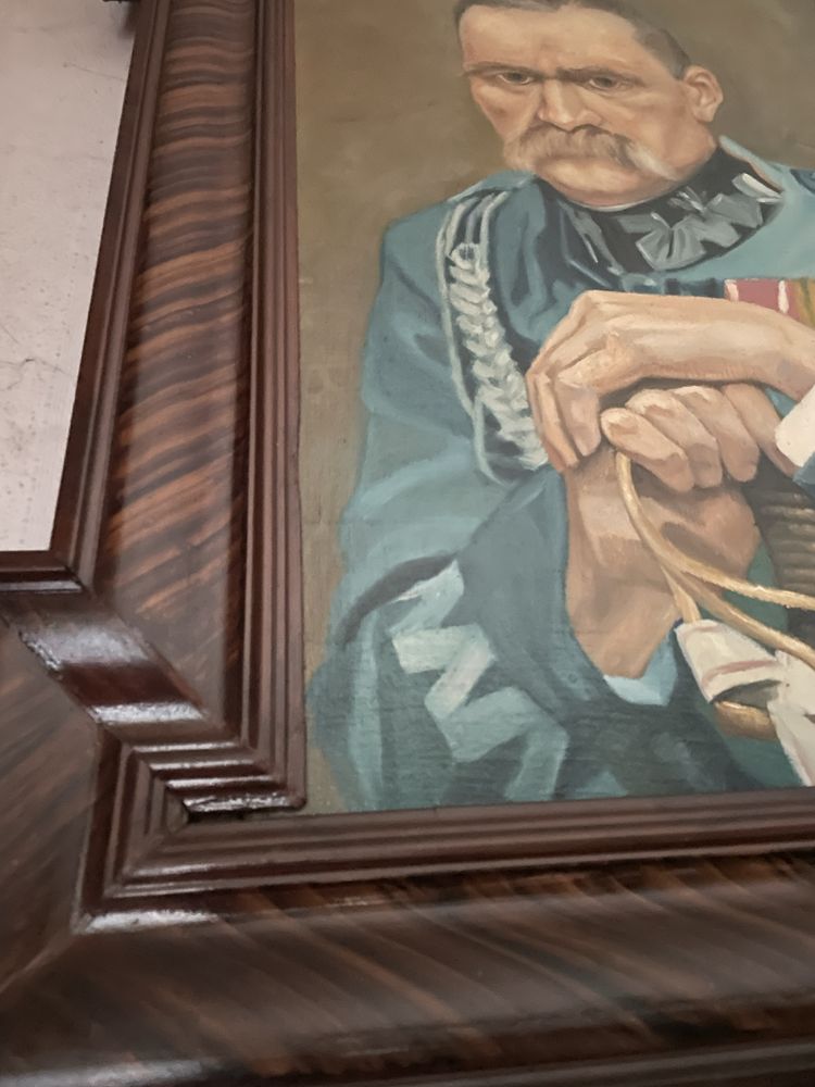 Obraz Józefa Piłsudzkiego w drewnianej ramie.