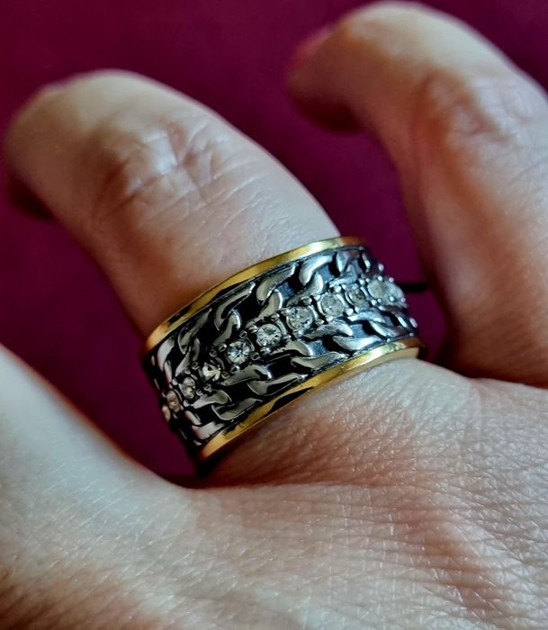 Anel bicolor, em aço, com fiada de zirconias no centro. T18