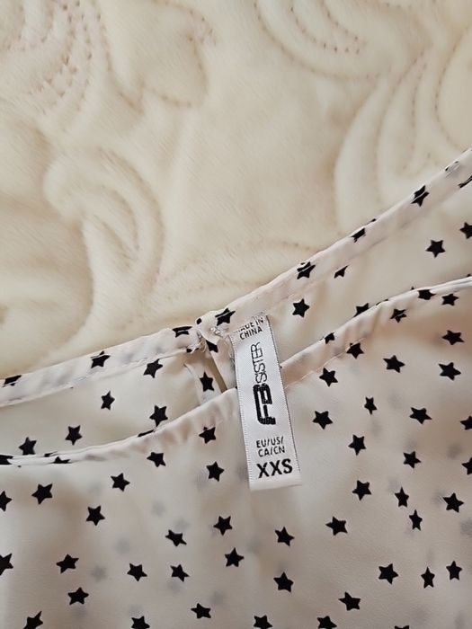 Святкова біла жіноча блузка із принтом в чорні  зірочки