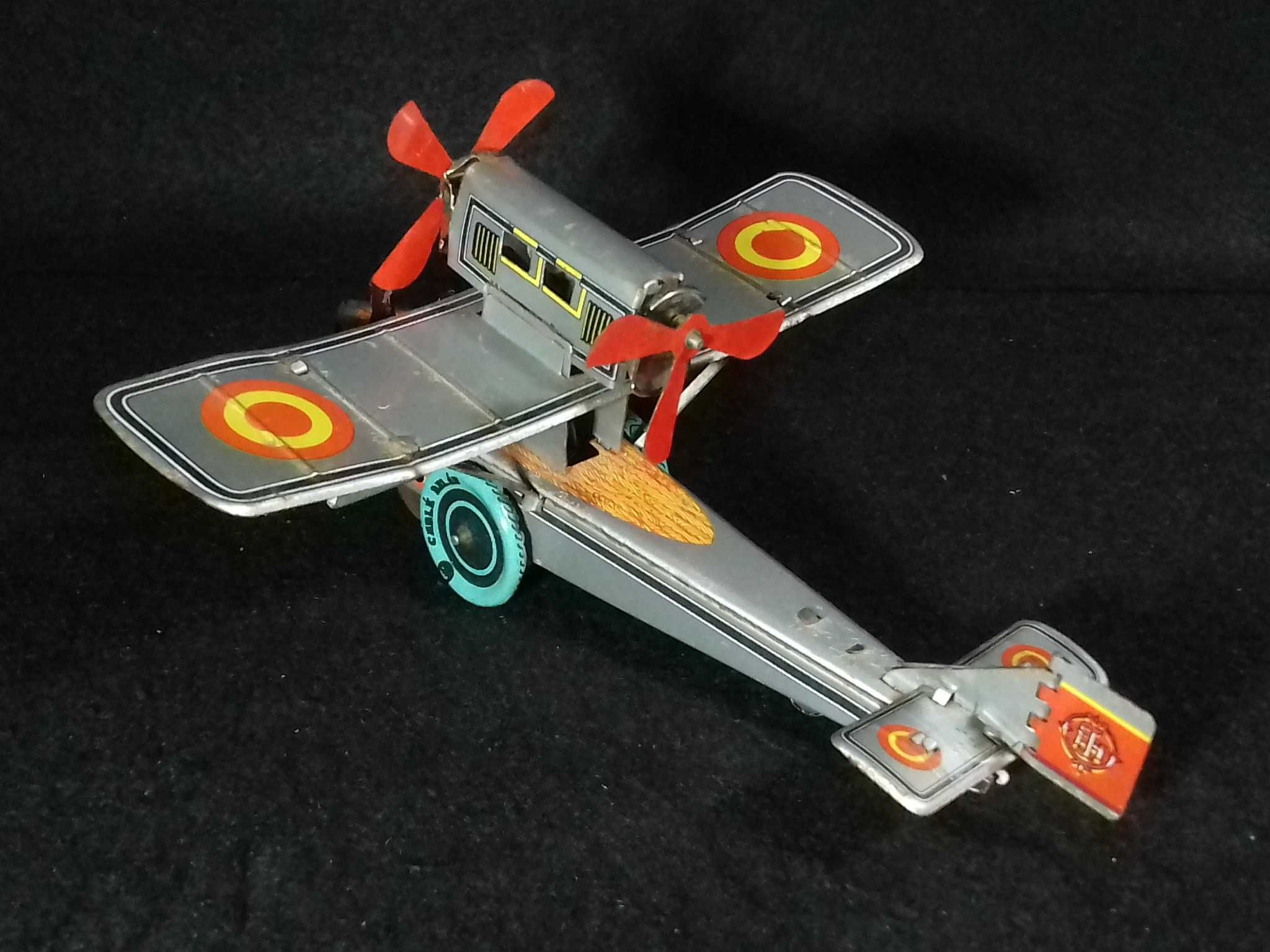 Miniatura de avião antigo em metal, com sistema mecânico de corda;