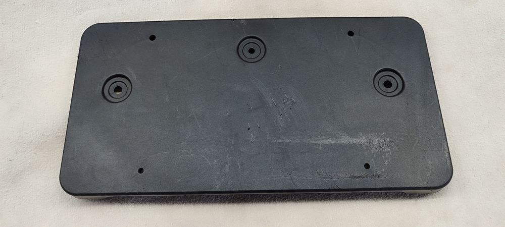 1018100-00-B кронштейн номерного знака Tesla. Подіум