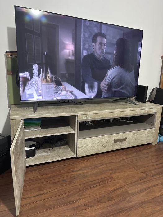 Móvel TV cor neutra com gavetas e prateleira interna.