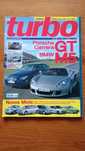 Revistas antigas com modelos Porsche e um livro.