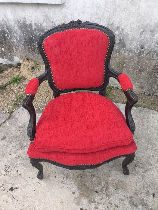 Cadeirão clássico com estrutura em madeira escura e estofo vermelho