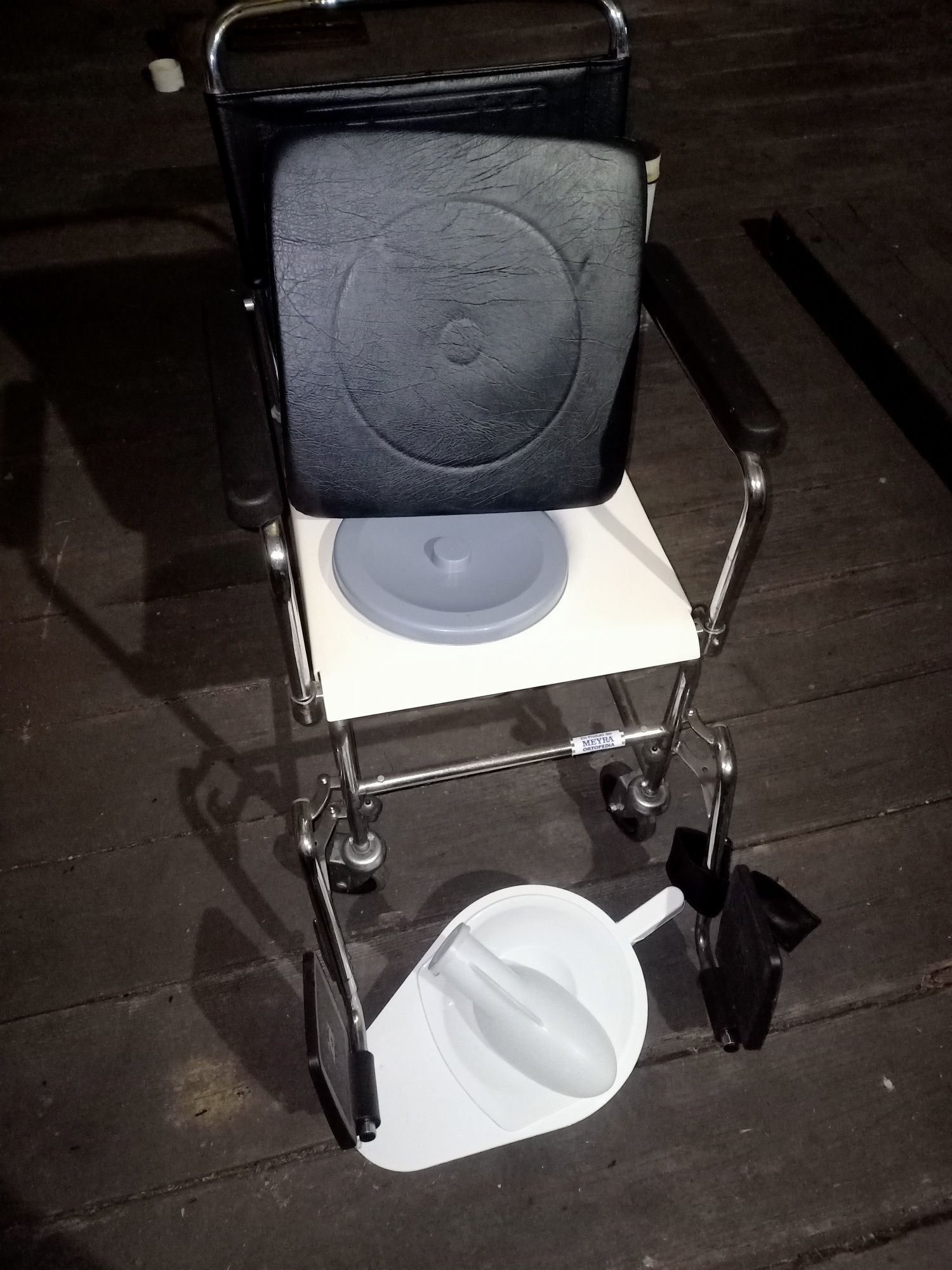 Fotel sanitarny , z podnóżkami na kółkach .