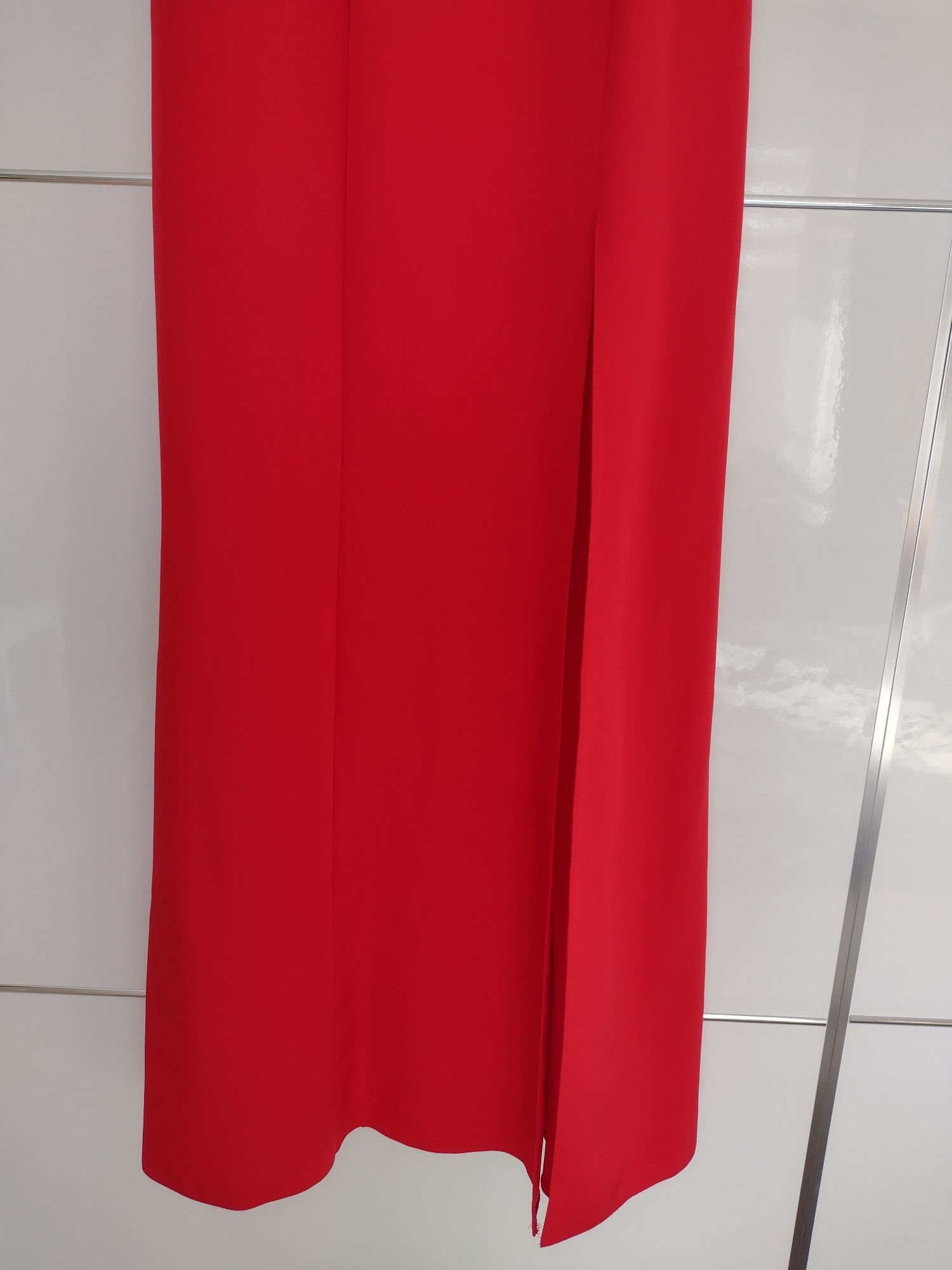 Długa czerwona sukienka rozcięcie na nodze odsłonięte ramiona